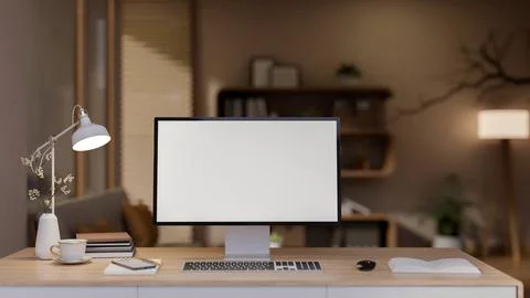 White screen computer and coffee cup and books aside on wooden table under .. Illustrazione stock