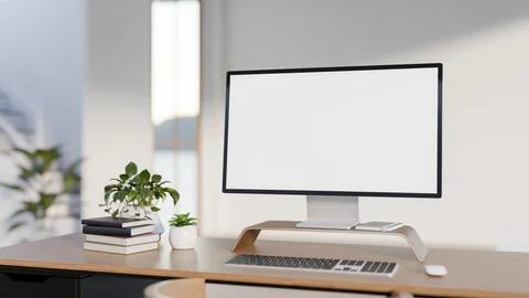 White screen computer with books and potted plants on wooden table across w.. イラスト素材