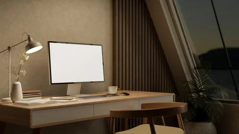 White screen computer with books aside lamp on wooden table and armchair in.. 스톡 일러스트