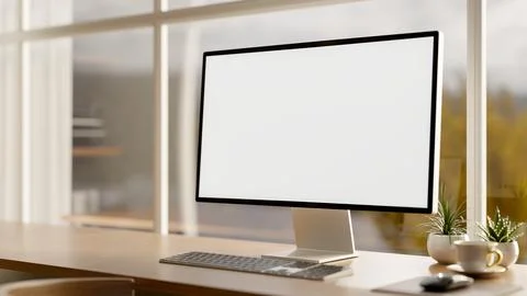 White screen computer with coffee aside plants on wooden table in a glass w.. Illustrazione stock