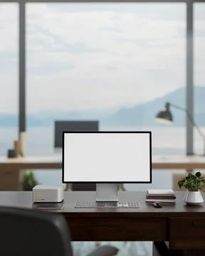 A white-screen computer mockup on a desk in a modern spacious office with a.. 스톡 사진