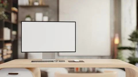 A white-screen computer mockup on a modern wooden desk in a contemporary offi Stock Photos