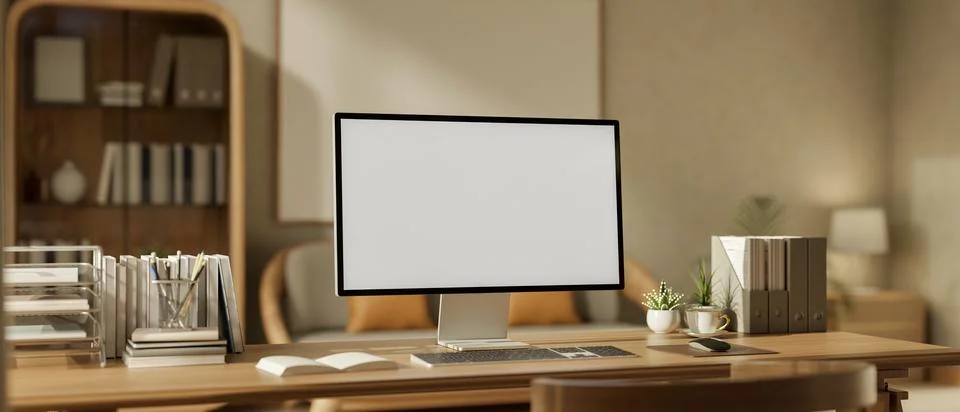 White screen computer with stationary and potted plants on wooden table in .. Illustrazione stock