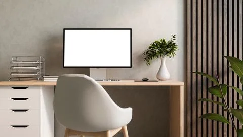White screen computer on wooden table with book and vase aside loft wall in.. Illustrazione stock