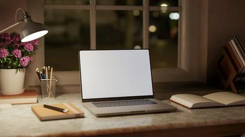White screen laptop with book and pencil aside flower pot on marble table u.. Stock Illustration