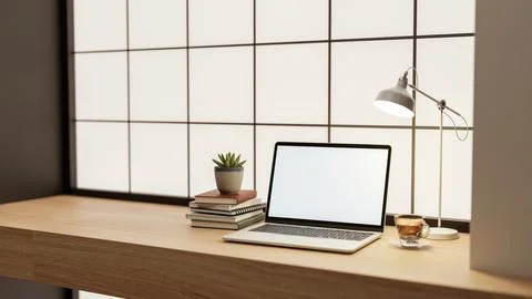 White screen laptop with coffee and books under lamp light on wooden counte.. Stock Illustration