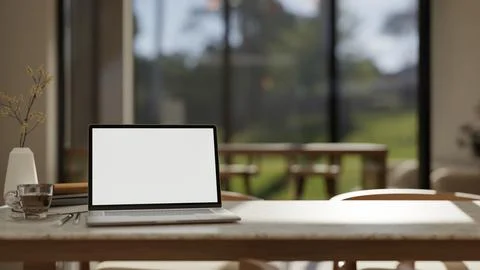 White screen laptop with coffee cup aside vase on marble table in a living .. 스톡 일러스트