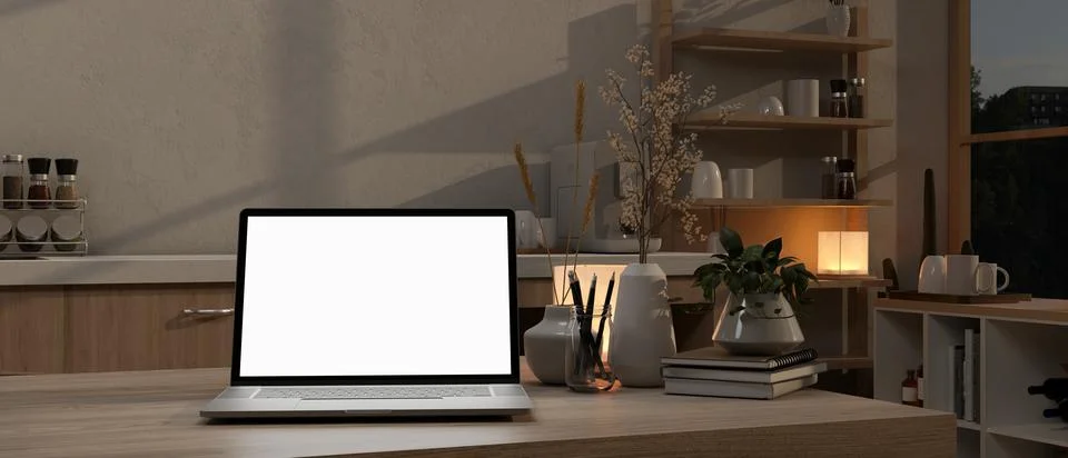 A white-screen laptop computer on a kitchen island in a modern kitchen at n.. Illustrazione stock