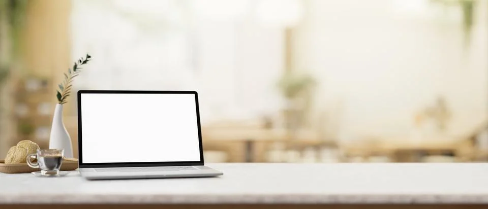 A white-screen laptop computer mockup on a white table in a cosy coffee shop. Stock Illustration