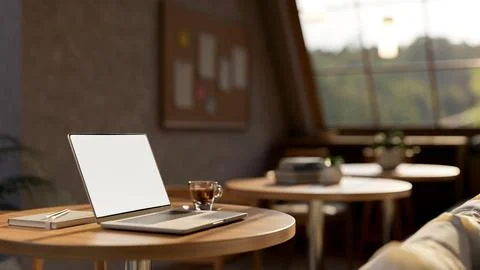 White screen laptops aside coffee cup and book on round wooden stool table .. 스톡 일러스트