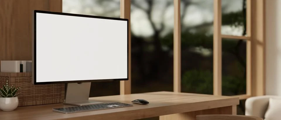 A white-screen PC computer mockup on a hardwood table in a cosy, modern roo.. イラスト素材