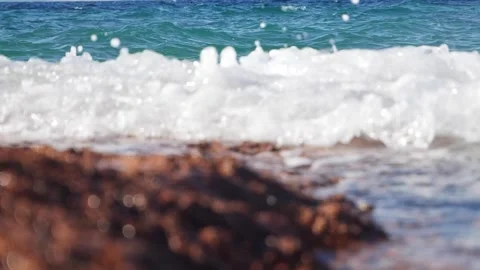 White sea foam splashes over rocky beach with blue ocean. Stock Footage 337406500