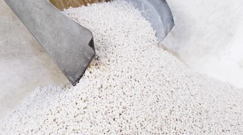 White secondary processing plastic granule comes out of the granulator crusher Stock Photos