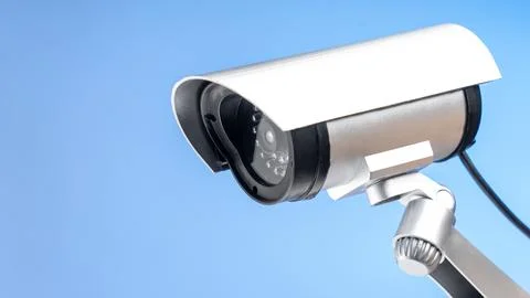 White security camera against clear blue sky Stock-Fotos