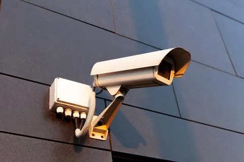 White security camera is attached on the territory of the business center. En Stock Photos