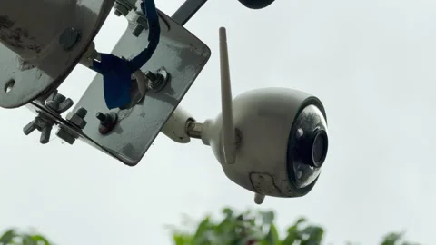 White security camera monitors outdoor area during rain Stock Footage 336878087