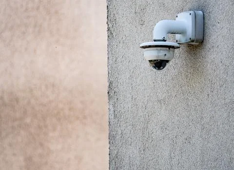 White Security Camera Mounted on Exterior Wall Stock Photos