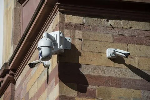 White security cameras of security on stoned wall by sunny day Stock Photos
