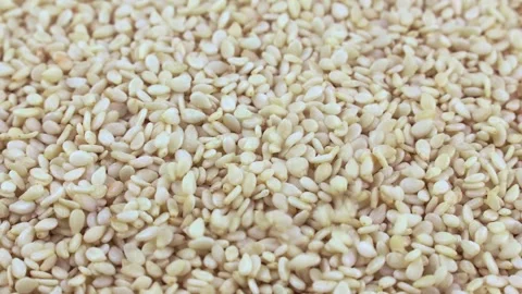 White sesame seeds falling down close up Stock Footage 244301650