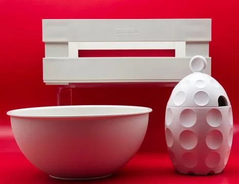 A white set of kitchen utensils isolated on red background. Stock Photos