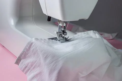 White sewing machine on a pink background. Electric sewing machine. white fabric Stock Photos