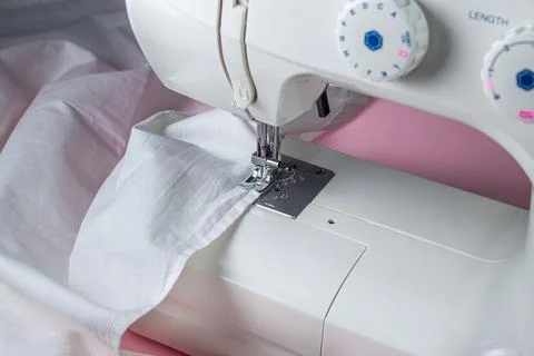 White sewing machine on a pink background. Electric sewing machine. white fabric Stock Photos