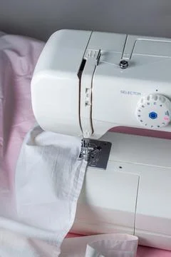 White sewing machine on a pink background. Electric sewing machine. white fabric Stock Photos