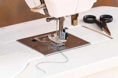 White sewing machine with scissors and thread Stock Photos