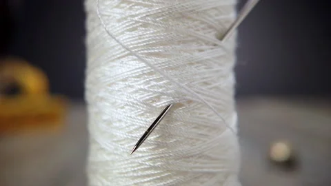 White sewing thread and a needle in a close up shot Stock Footage 171390417