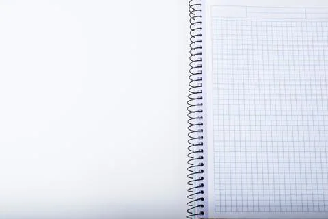 A white sheet and an open squared notebook on a spiral. Isolate. Copy space. Stock Photos