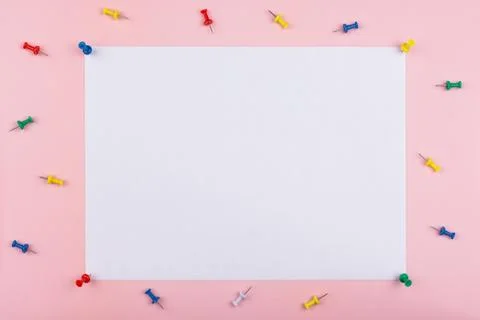White sheet fastened with clerical multi-colored buttons on a pink background Stock Photos