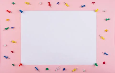 White sheet fastened with clerical multi-colored buttons on a pink background Stock Photos