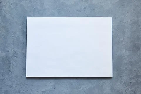 White sheet on gray concrete background. Copy space. Blank mockup on a neutral Stock Photos
