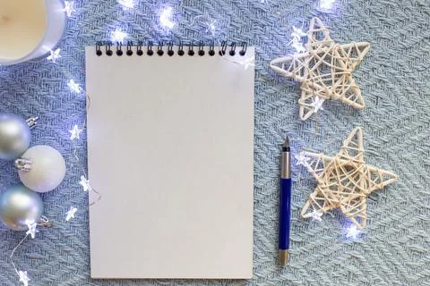 White sheet of notebook, lies on a blue knitted blanket Stock Photos