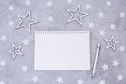 White sheet of notebook with pen on festive gray background. Stock Photos