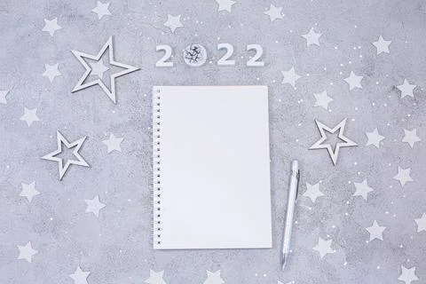 White sheet of notebook with pen on festive gray background. Stock Photos