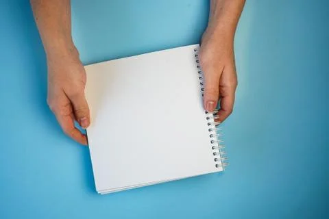 White sheet of Notepad in two hands, copyspace Stock Photos