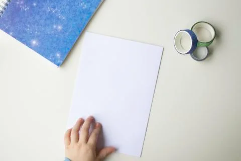 A white sheet of paper, a blue note with snowflakes, colored decorative scotc Stock Photos