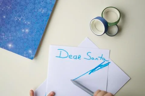 A white sheet of paper, a blue note with snowflakes, a felt-tip pen and a shi Stock Photos