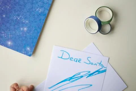 A white sheet of paper, a blue note with snowflakes, a felt-tip pen and a shi Stock Photos