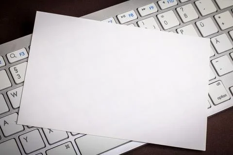 White sheet of paper on computer keyboard Stock Photos