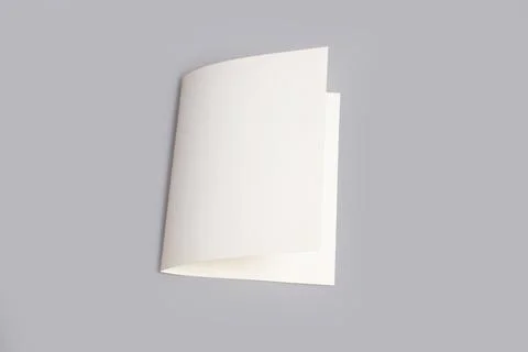 A white sheet of paper folded over a gray background with copy space Stock Photos