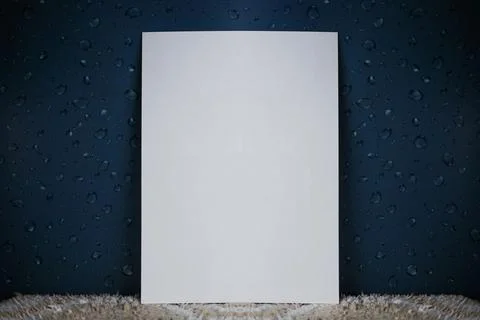 A white sheet of paper stands vertically with water drops Stock Photos