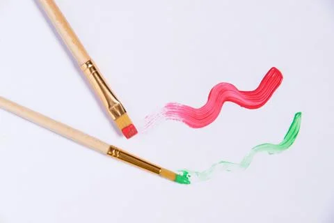 White sheet of paper with two brushes and painted red and green waves, place  Stock Photos