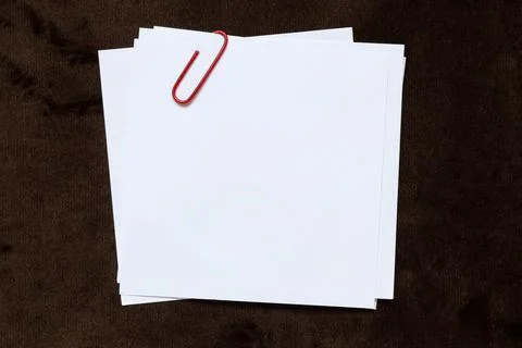 A white sheet of square-shaped paper lies on a brown velour background as a.. Stock Photos