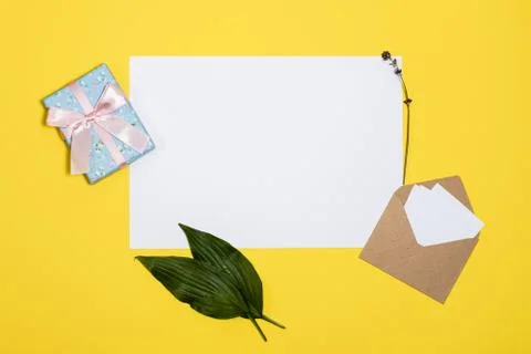 White sheets, envelope, gift box  lie  on a yellow background Stock Photos