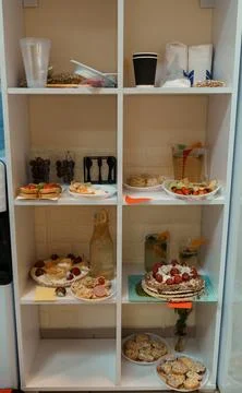 White Shelving Unit Displaying an Array of Snacks and Beverages in a Bright.. Foto stock