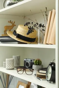 White shelving unit with straw hat and different decorative elements 写真素材