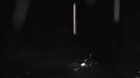 White shimmer falling on the black background, abstract slow motion Stock Footage 75974297