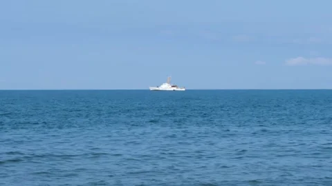 White ship floating in the distance on the blue water with beautiful horizon Видео 301917224